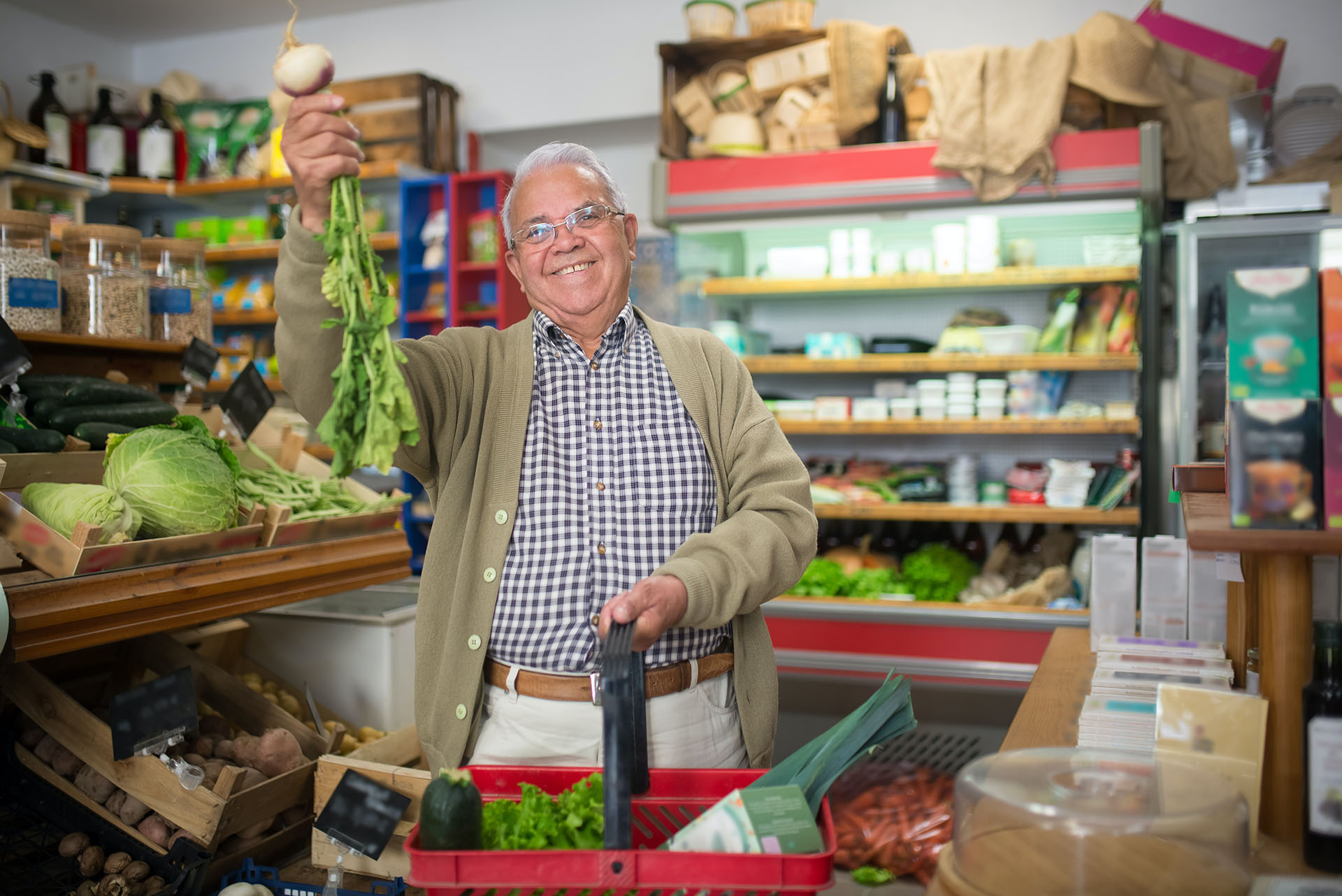 A happy man finding fresh produce in a store.